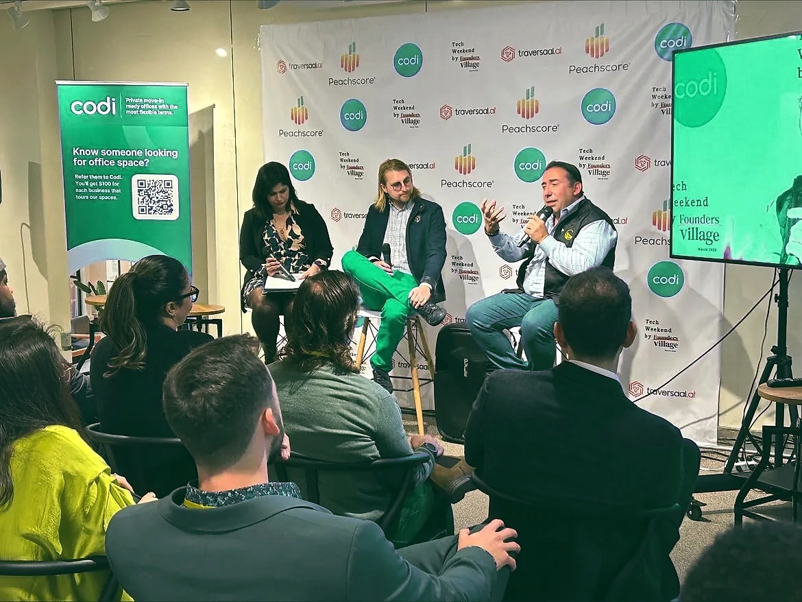 Three panelists in conversation in front of a Peachscore backdrop while an audience listens