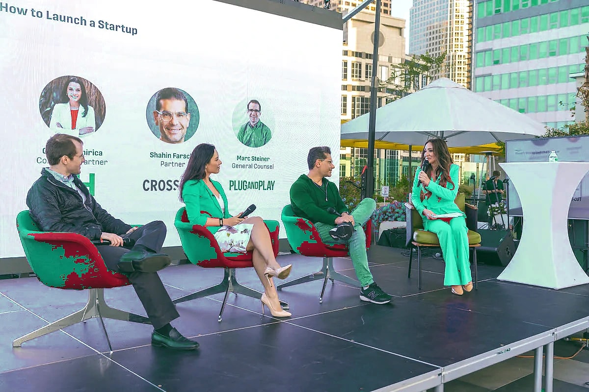 Panelists seated on an outdoor stage during a startup panel discussion